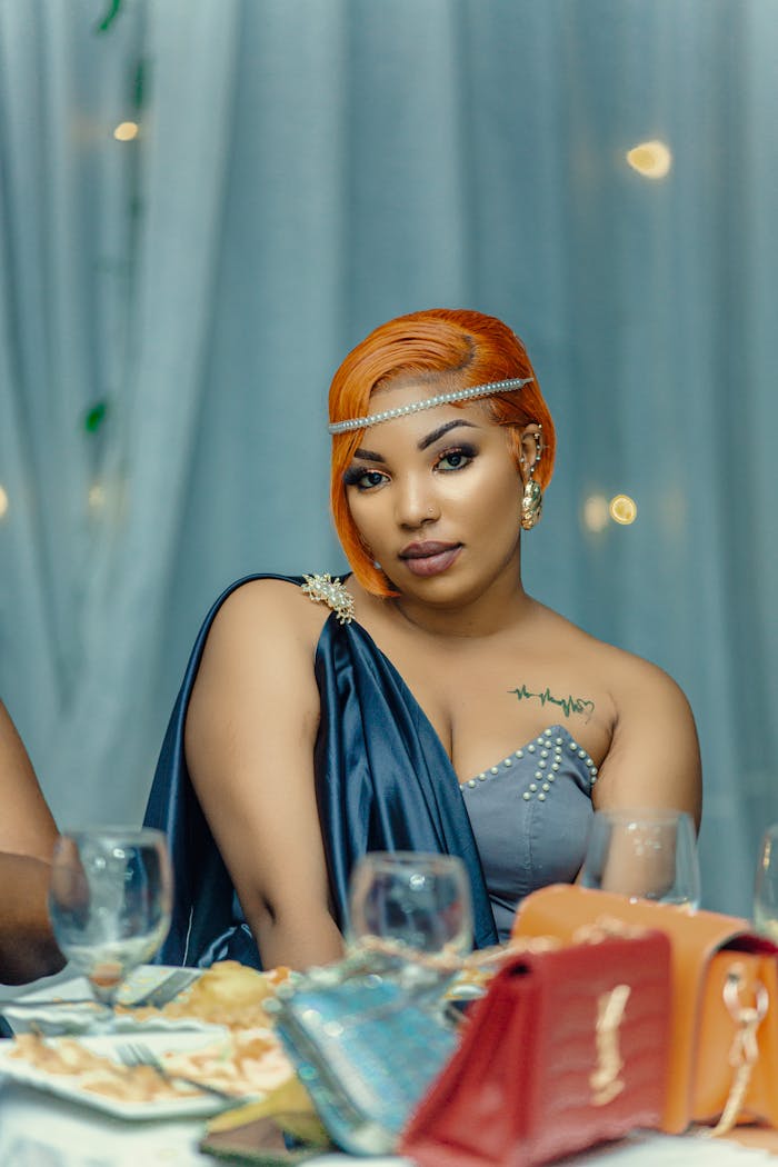 Elegant woman with orange hair at a formal dinner setting, exuding confidence.