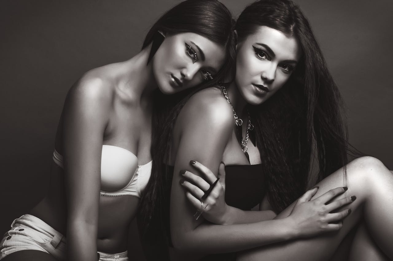 Artistic black and white photo of two women posing in lingerie during a photoshoot.